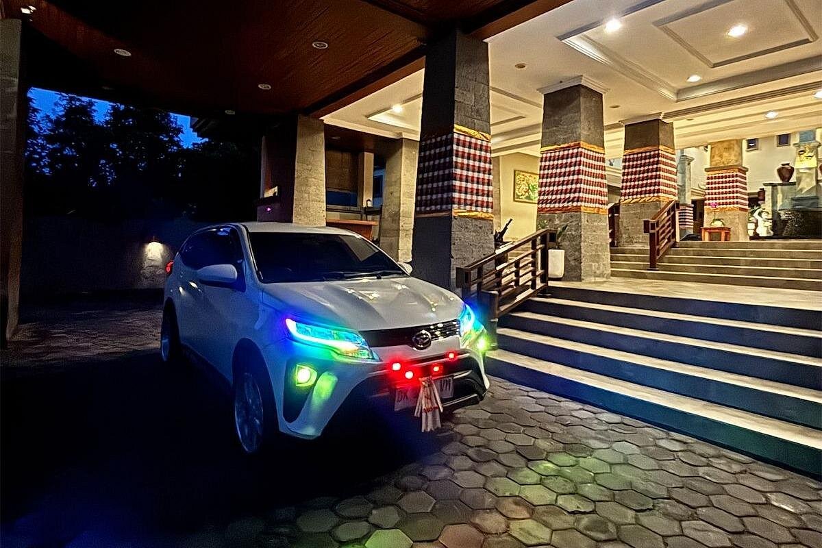 Private vehicle waiting at Balinese hotel entrance with traditional decor