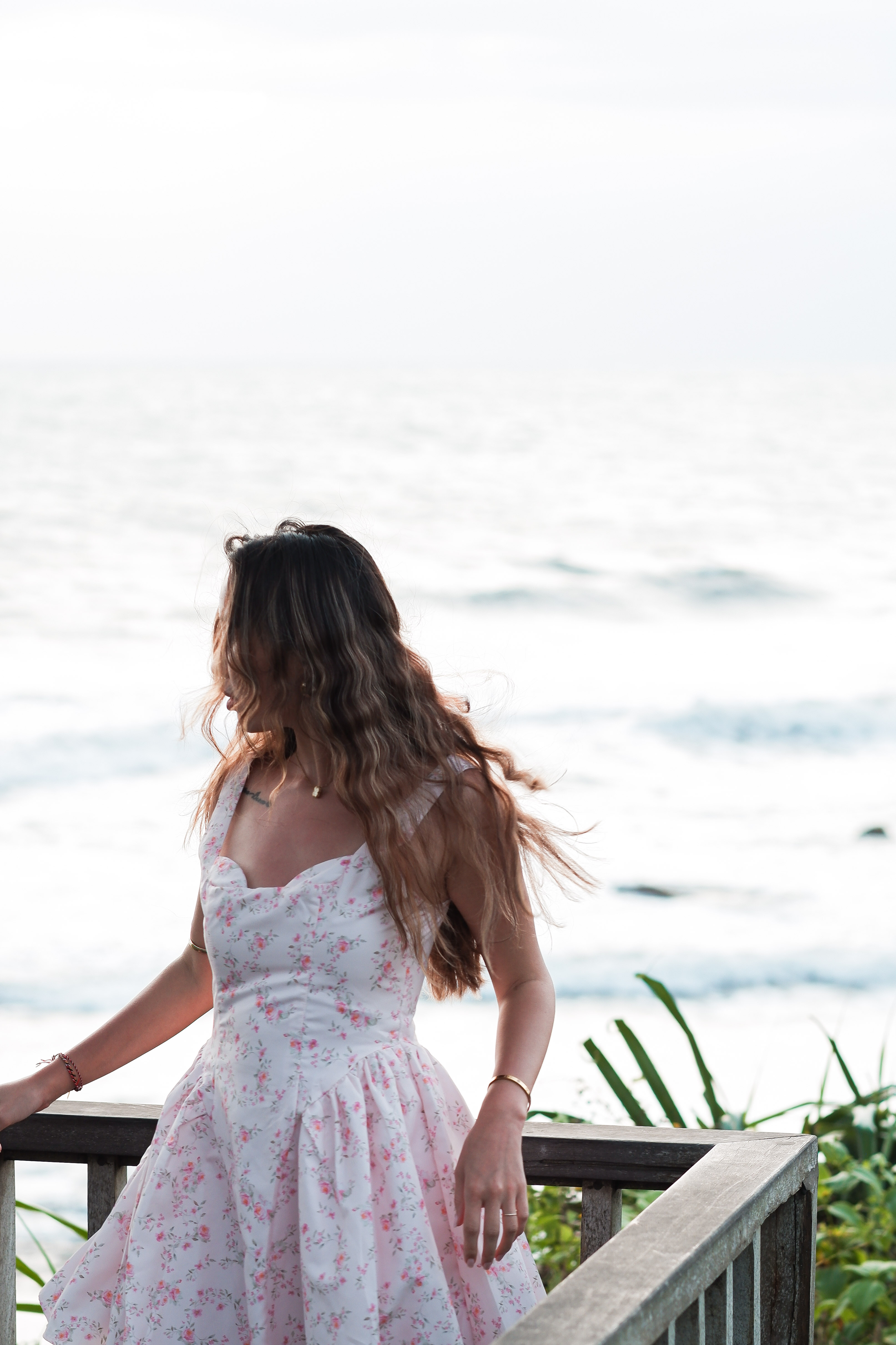 Traveller looking out at the ocean from a coastal pier railing