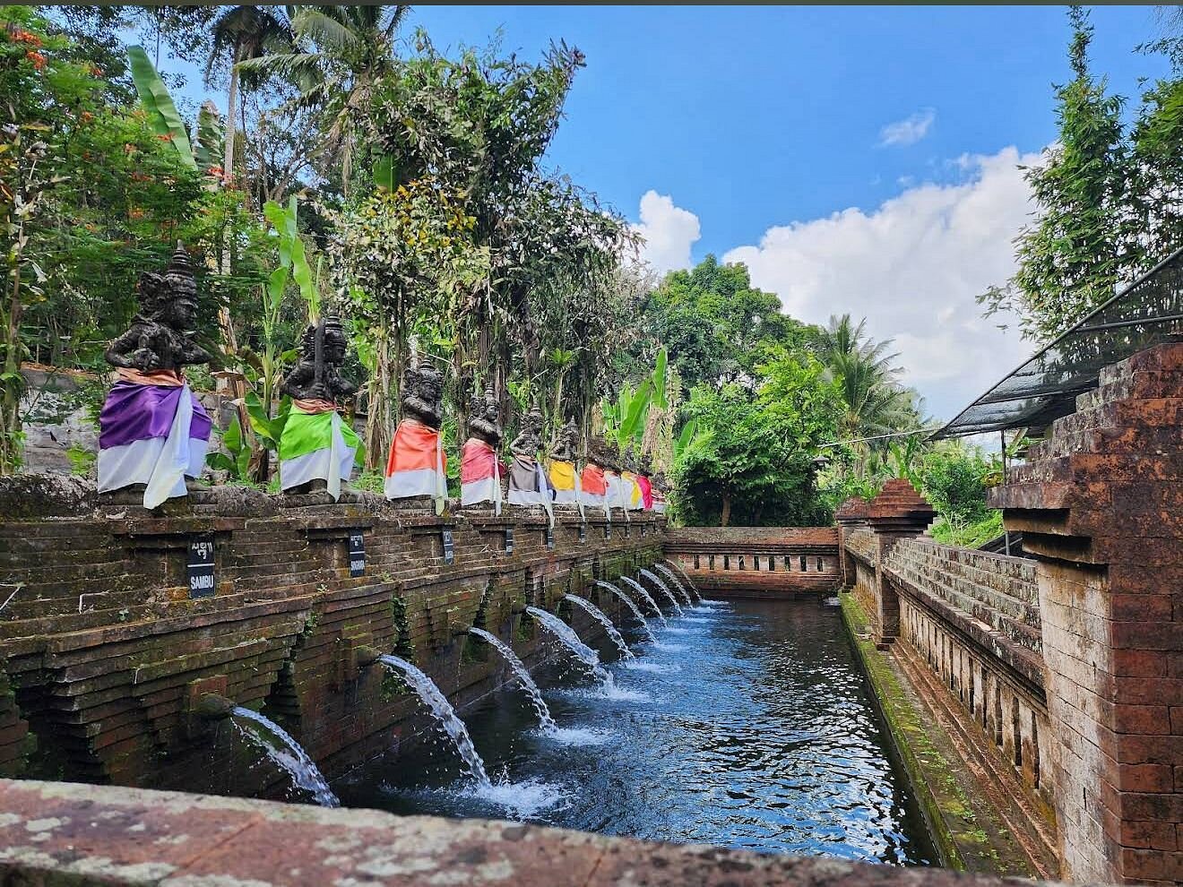 Taman Mumbul holy spring with red ceremonial umbrellas
