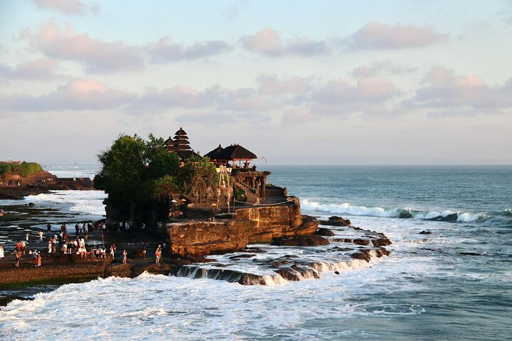 Tanah Lot sea temple with crashing tide and golden sky