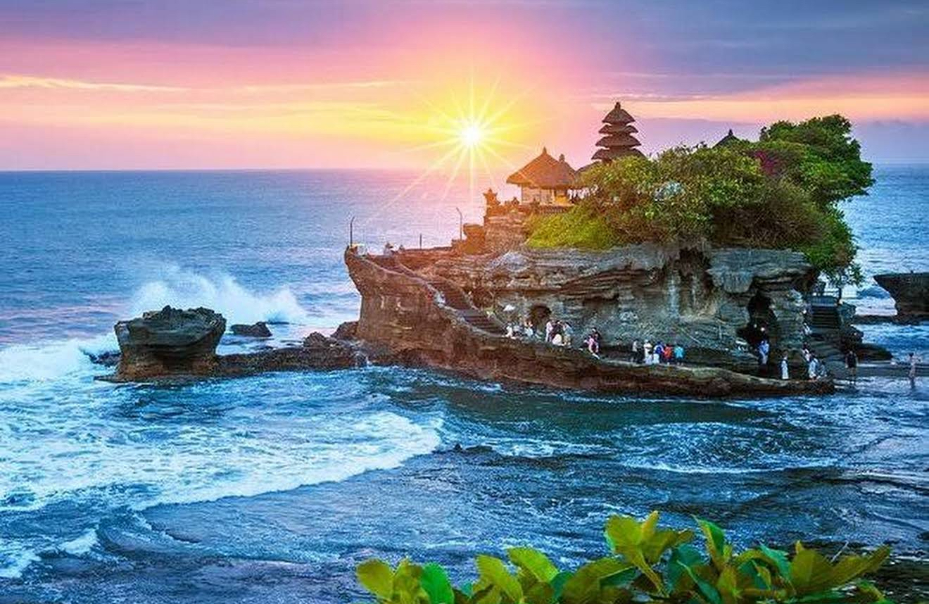 Tanah Lot temple at sunset with waves breaking on the rocks