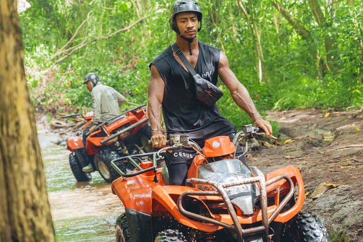 ATV adventure splashing through a jungle stream crossing