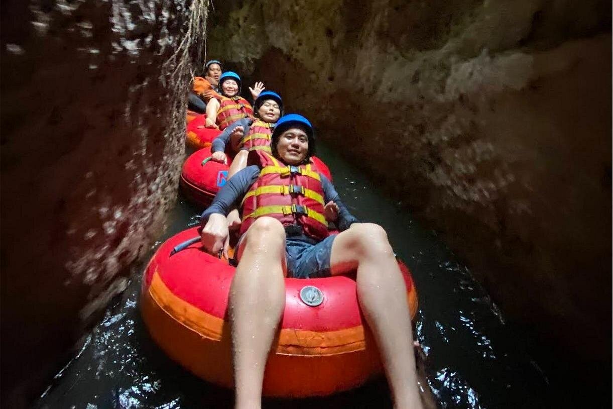 Smiling guests on river tubing chain through canyon