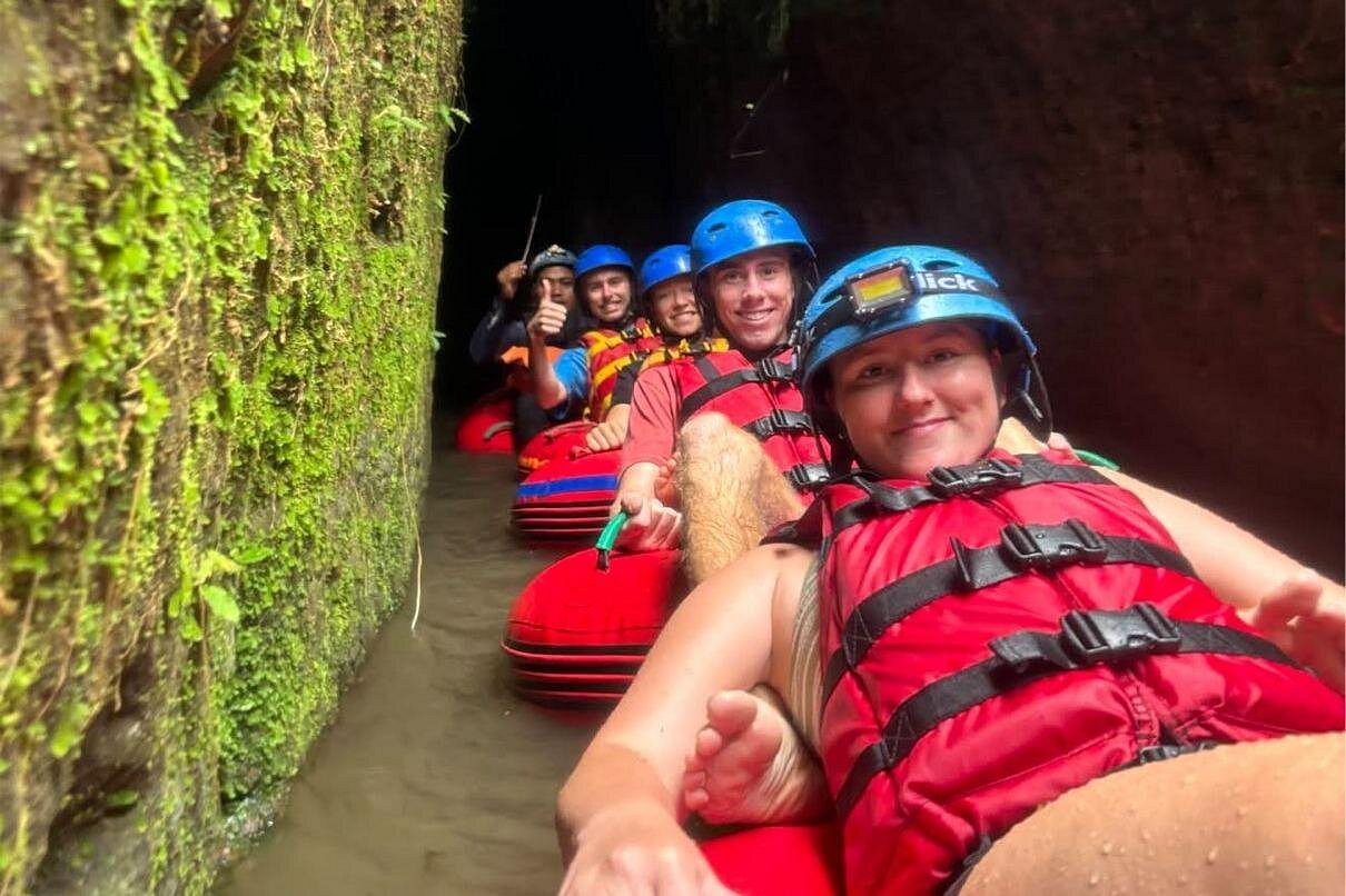 Tubing chain navigating jungle river canyon together