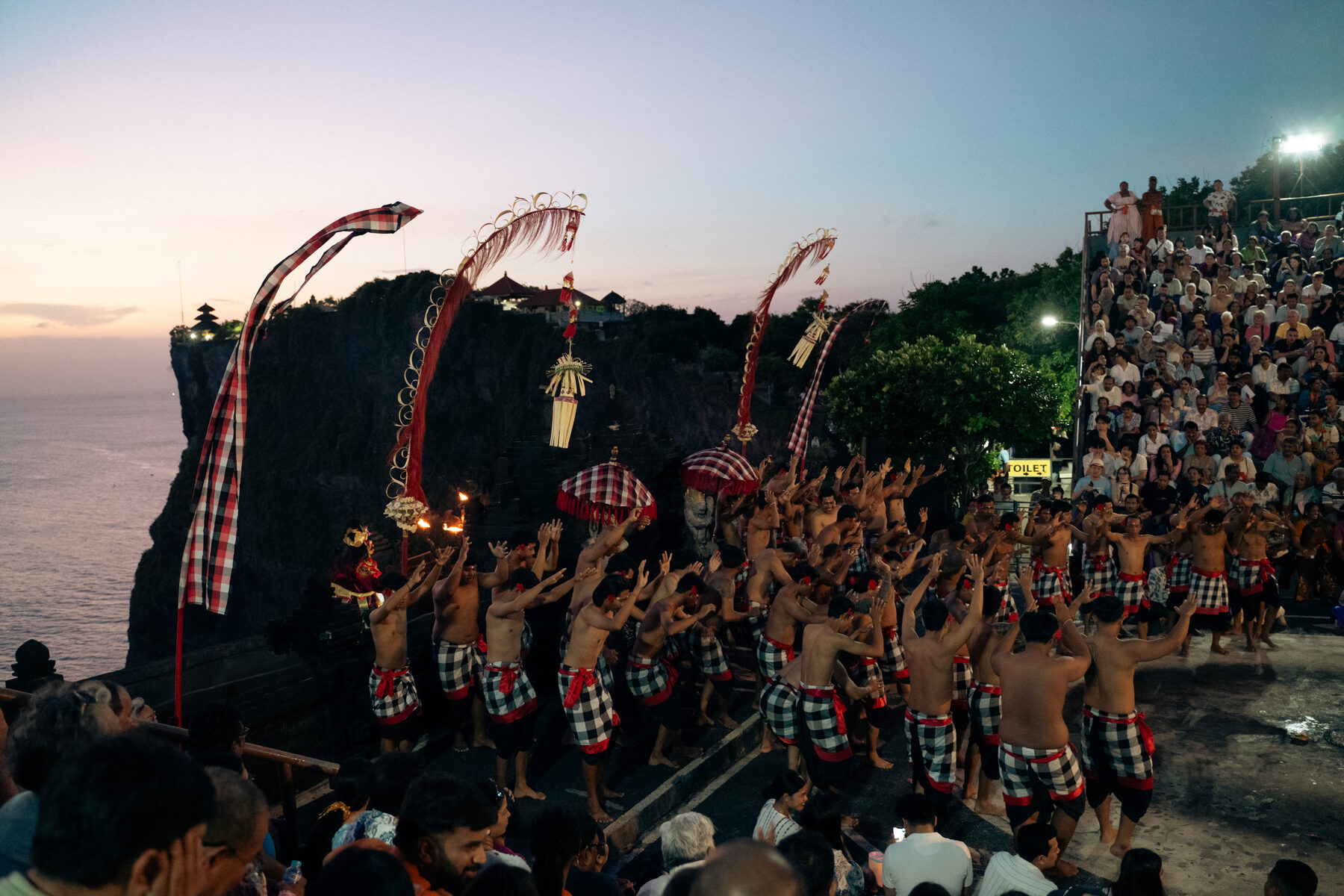 Peak fire moment of the Kecak dance surrounded by chanters at the Uluwatu cliff