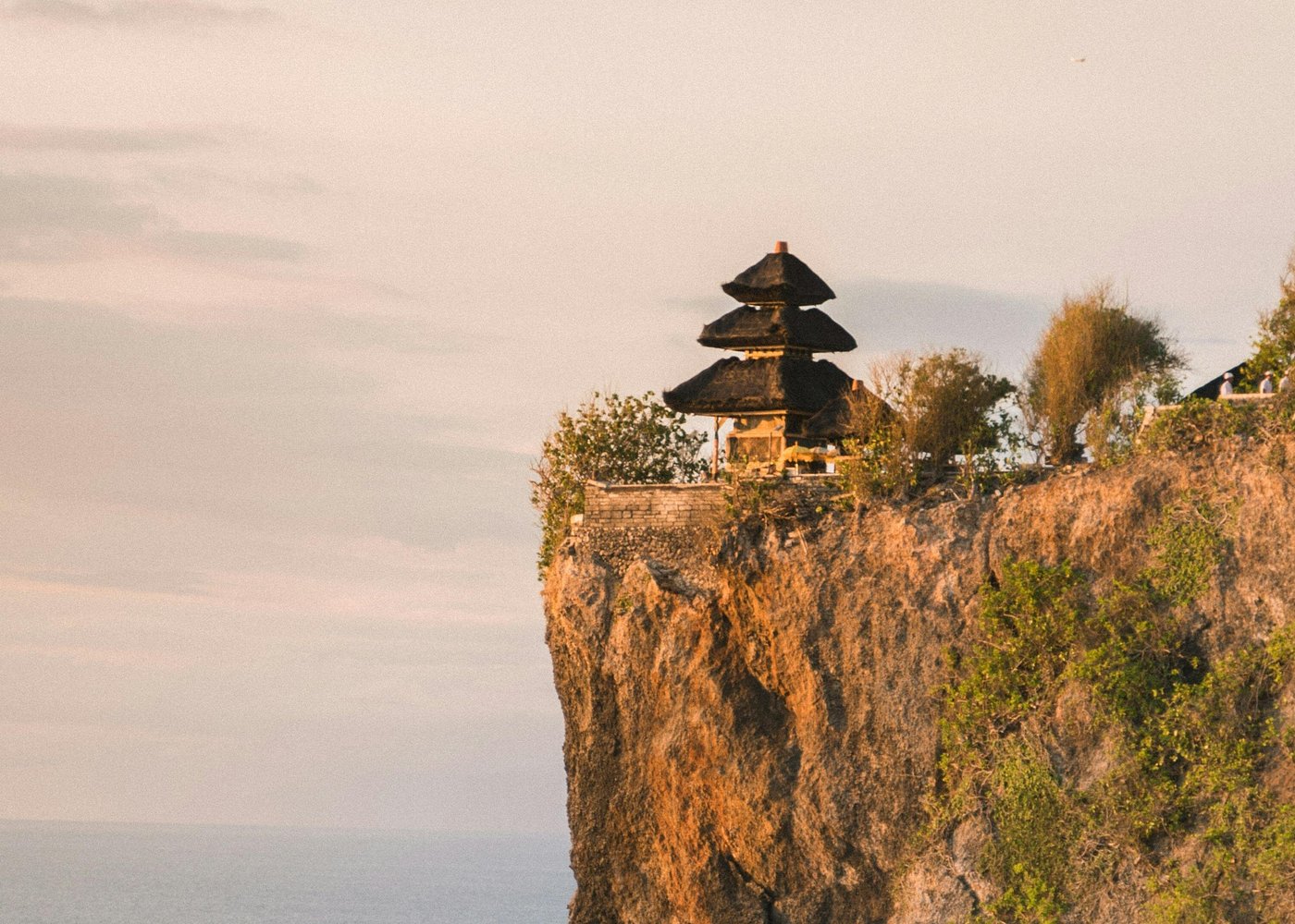 Uluwatu cliff temple at sunset with the Indian Ocean breaking against the rocks below